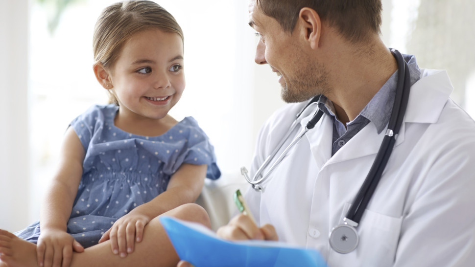 Shot of a handsome male doctor with an adorable young girl for a patient